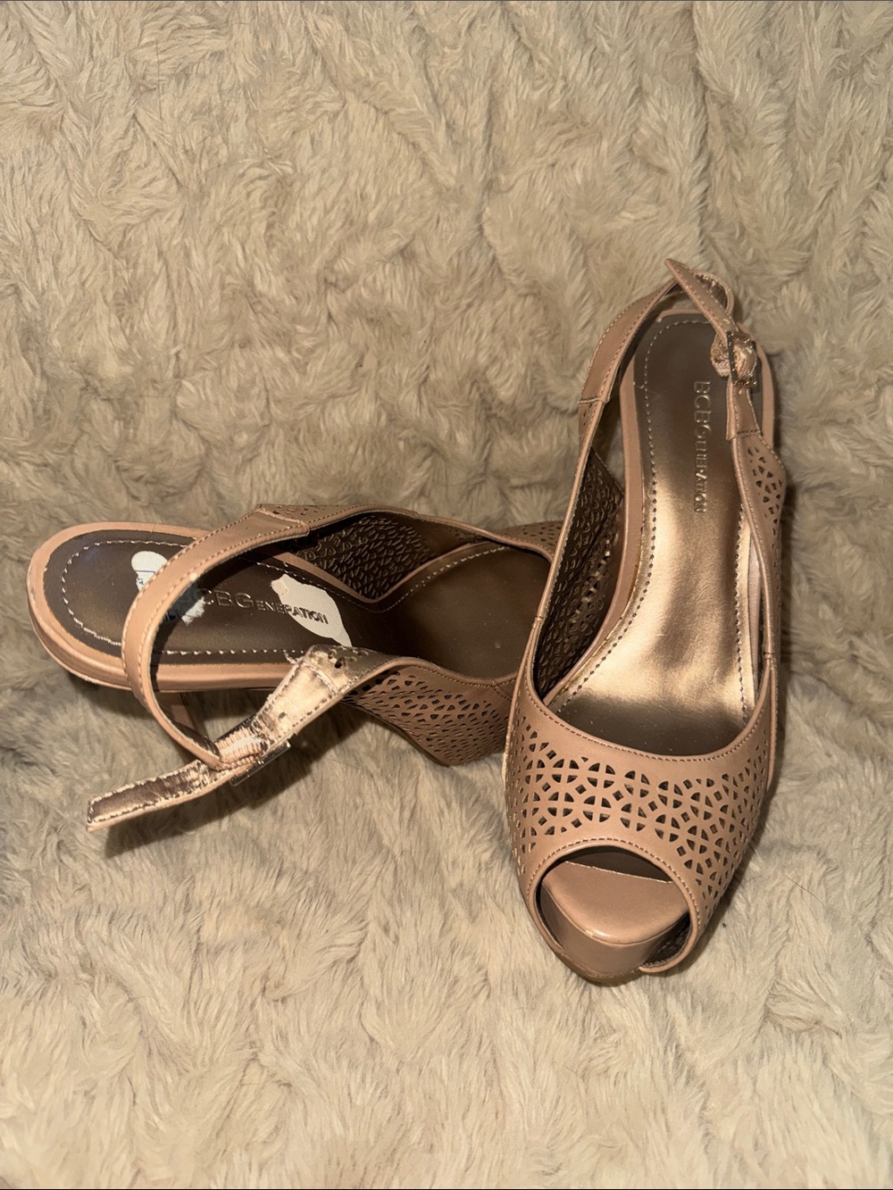 BCBGeneration laser-cut, nude slingback pumps with a peep toe.